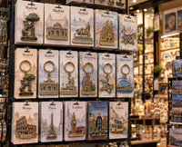 Expositor de tienda de souvenirs con pins, llaveros, imanes y charms metálicos personalizados de Madrid, Barcelona y otras ciuda